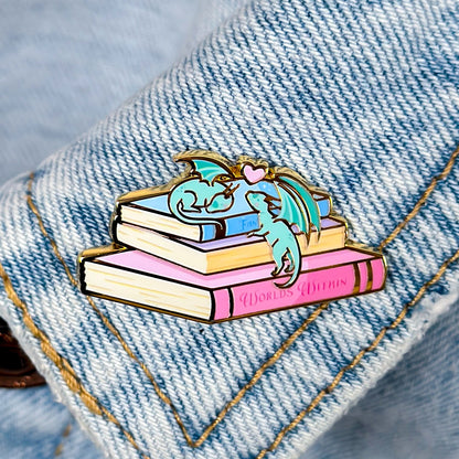 Pin with a dragon on books on a denim background