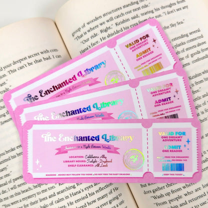 Three 'The Enchanted Library' tickets on an open book
